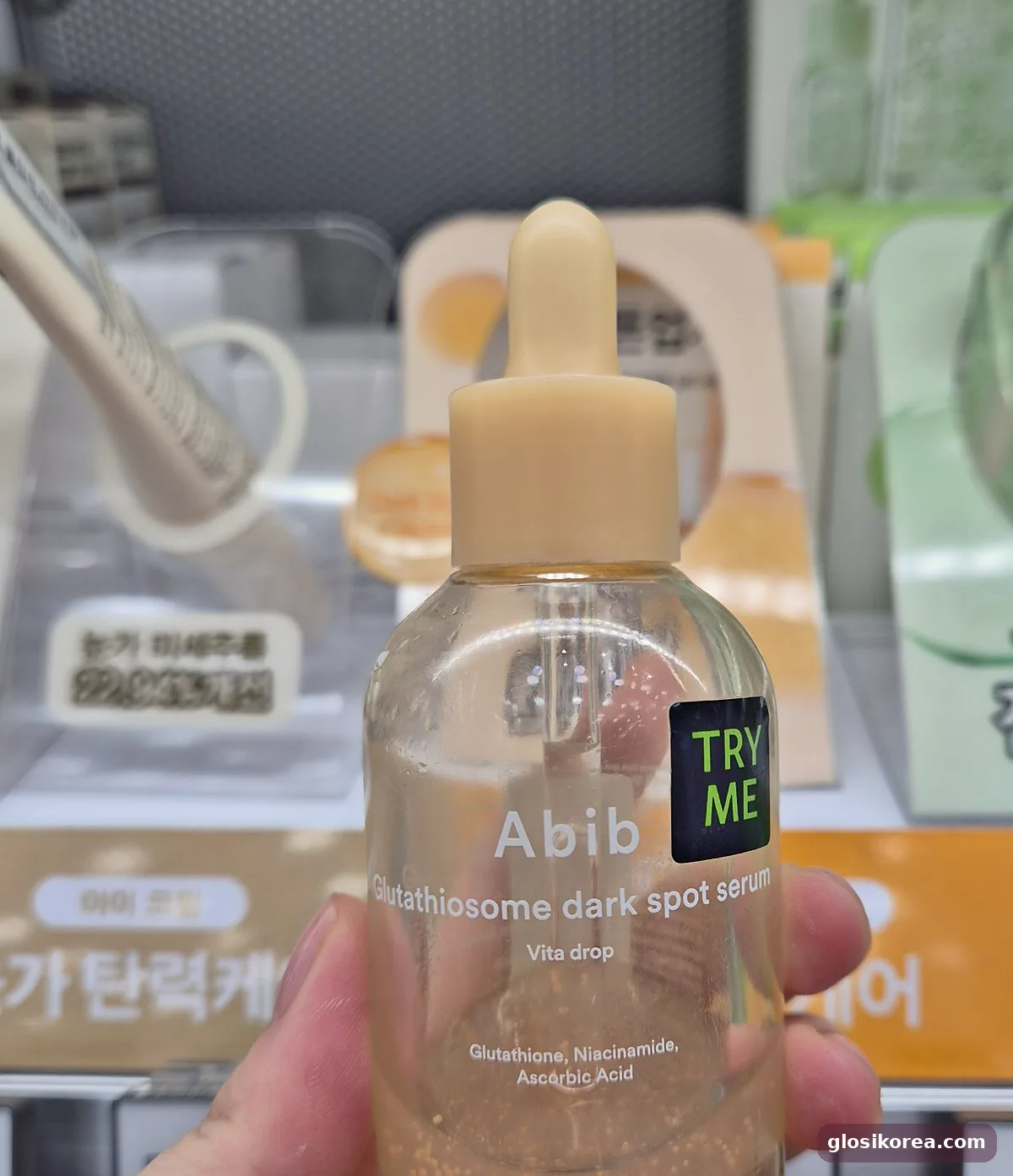 Abib Glutathiosome Dark Spot Serum Vita Drop with orange capsules held in hand