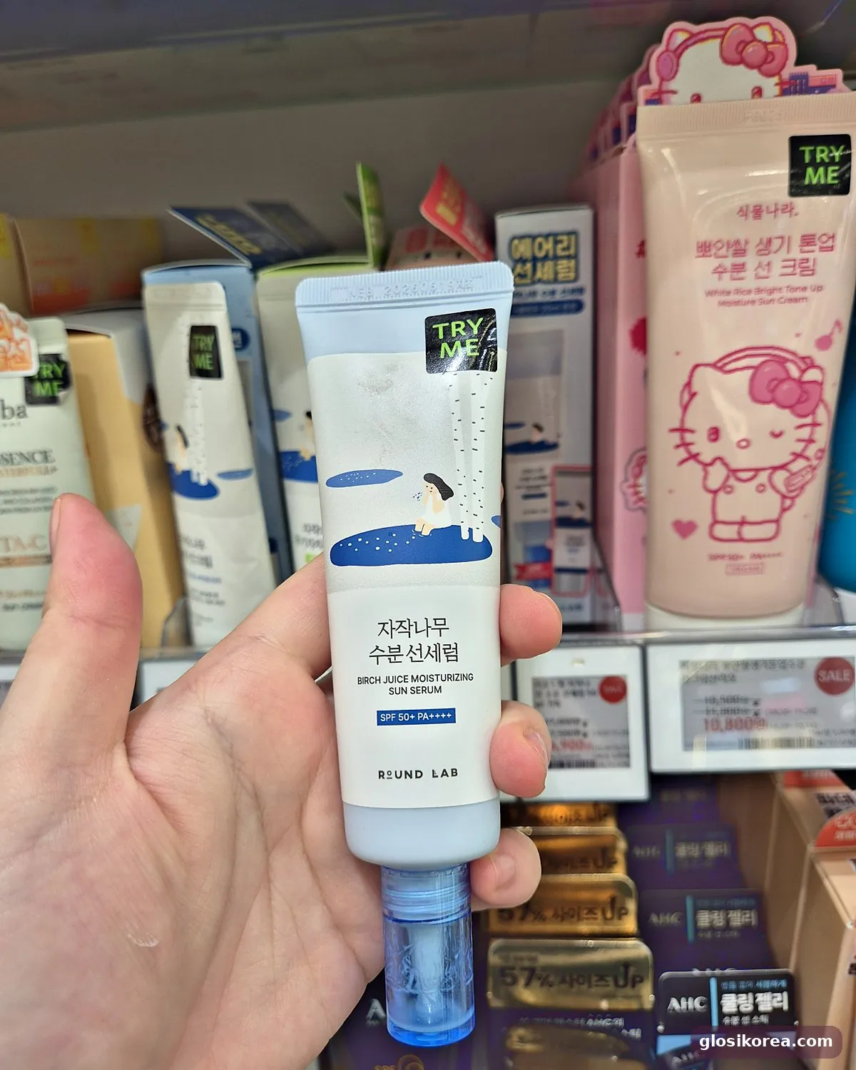 ROUND LAB Birch Juice Moisturizing Sun Serum held in hand at Olive Young