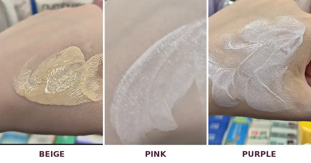 Beige, pink and purple Korean tone-up sunscreen swatches side by side on my hand